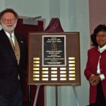 Dock Burke and Naomi Lede standing beside a plaque
